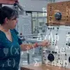 Profesora trabaja con máquina en investigación sobre mecánica cuántica