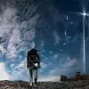Work titled Human Trash that represents a human figure made of waste walking amongst a pile of garbage towards a blue sky, next to a tree with plastic leaves.