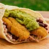 Burrito vegano que contiene  tortilla sin gluten, pollo vegano sin gluten, frijoles, arroz y guacamole.