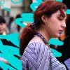 Joven lectora lee un libro en stand de la Feria Internacional del Libro 2025