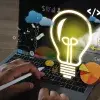 fotografía de una computadora con ilustraciones de bombilla de luz, cohete, ideas