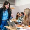 Profesora interactuando con 2 estudiantes jóvenes
