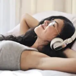 Joven acostada escuchando música