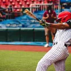 Estudiante bateando durante juego de liga de prospectos