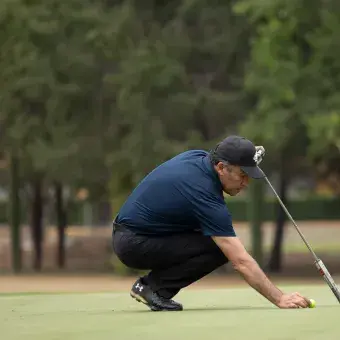 Jugador posicionando la pelota en el green