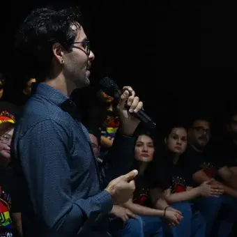 Hombre hablando con un micrófono en mano. 