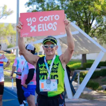 Persona sosteniendo un letrero de la carrera