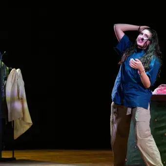 alumna caracterizada como trabajadora de lavandería para su presentación de monólogo