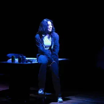 alumna caracterizada en su presentación de monólogo bajo una luz azul