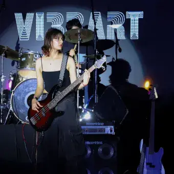 alumna tocando el bajo junto a su banda 