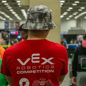 Alumno de espaldas en torneo de robótica. 