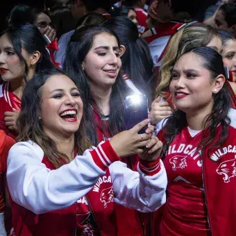 Integrantes del elenco de High School Musical: On Stage se toman una selfie entre risas y abrazos tras finalizar la obra, vistiendo chamarras rojas de los Wildcats en el campus Hidalgo.