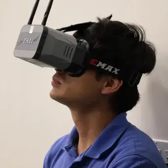 Estudiante con lentes de realidad virtual, controlando un drone.
