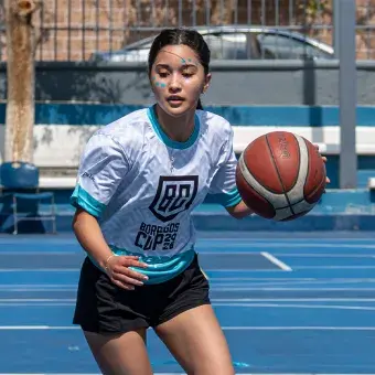 Alumna con balón en basquetbol jugando