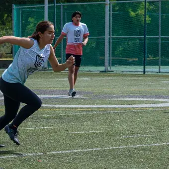 Alumna jugando fútbol persiguiendo el balón