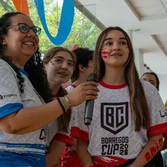 Alumna sonriendo viendo hacia una pantalla