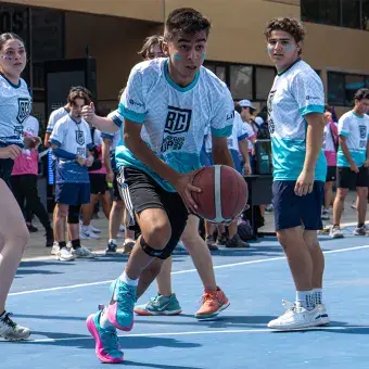 Alumno corriendo hacia la canasta